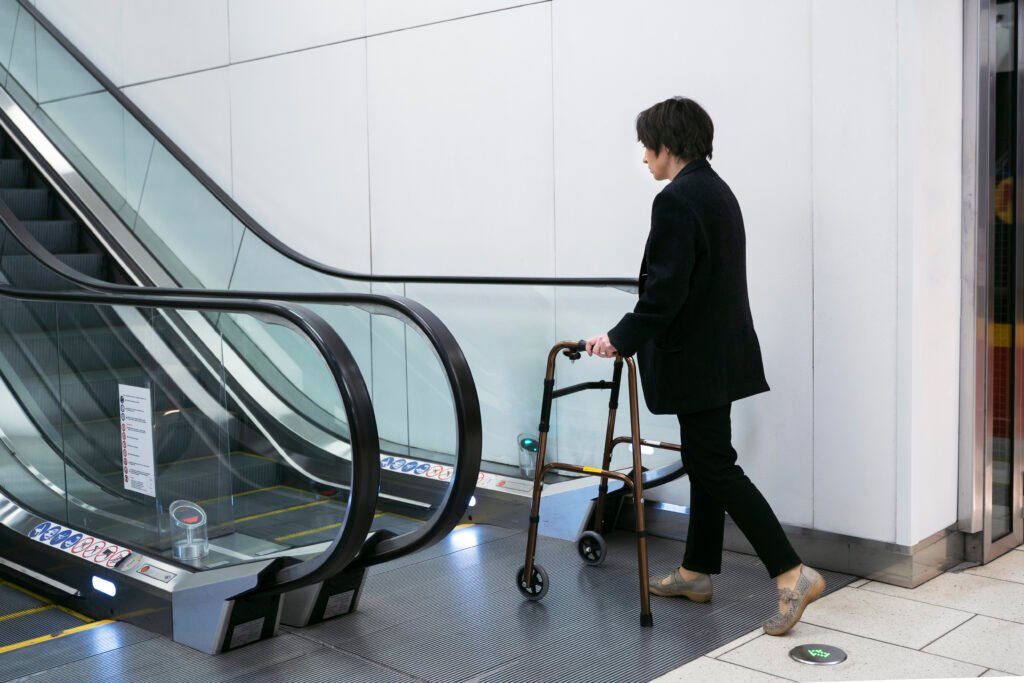 full shot adult with walking frame near escalators